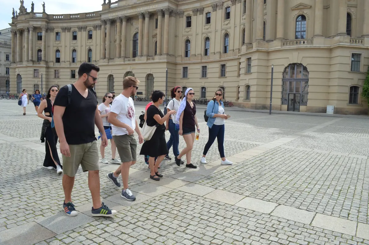 Grupo atravessando a Bebelplatz diante da Universidade Humboldt